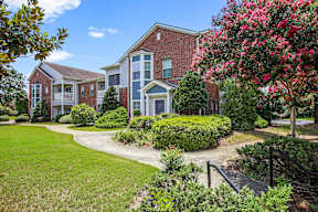 A row of houses with a green lawn in front.