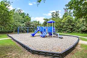 A playground with a blue slide and a blue and white canopy.