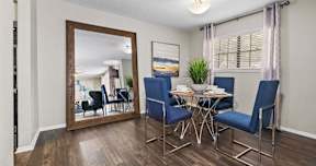 a dining room with a mirror and a table and chairs