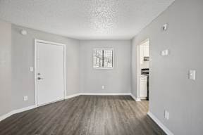 A room with a white door and a window with bars on it.