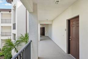 A long hallway with a brown door at the end.