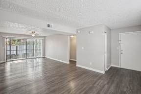 A spacious room with wooden floors and white walls.