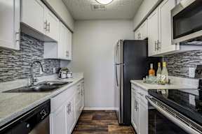 a kitchen with stainless steel appliances and white cabinets