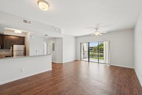 A spacious room with wooden floors and a ceiling fan.