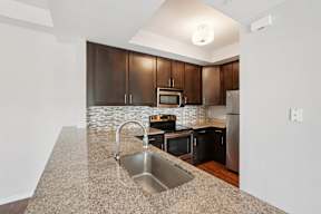 A kitchen with a granite countertop and stainless steel appliances.