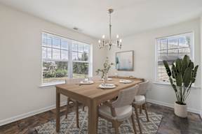 A dining room with a wooden table and chairs.