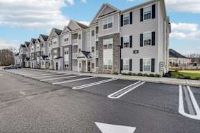 A parking lot in front of a building with apartment number 23.