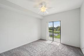 A room with a ceiling fan and carpeted floor.