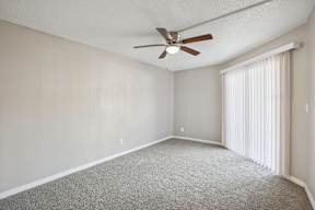 A room with a ceiling fan and carpeted floor.