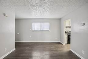A room with a window and a wooden floor.