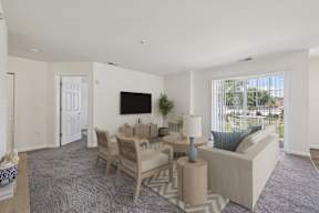 A living room with a grey carpet and a white sofa.