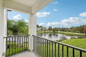 A balcony overlooks a pond and a park.