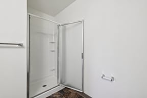 A white bathroom with a glass shower door.