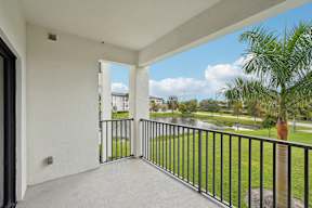 A balcony with a view of a road and trees.