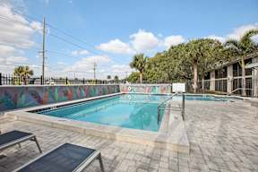 A pool with a mural on the wall next to it.
