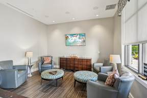 A living room with grey chairs and a painting on the wall.