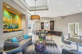 A modern living room with a grey sofa and a large abstract painting on the wall.