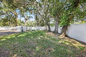 A white fence encloses a green park area.