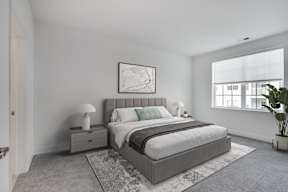A bedroom with a large bed and a plant.
