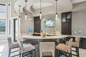A kitchen with a large island and chairs around it.