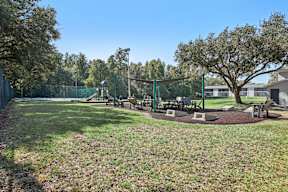 A park with a playground and picnic tables.