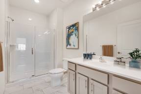 A bathroom with a toilet, sink, and mirror.