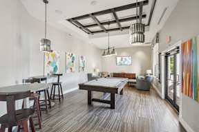 A room with a pool table and a painting on the wall.