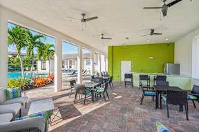 A patio with a table and chairs overlooking a pool.