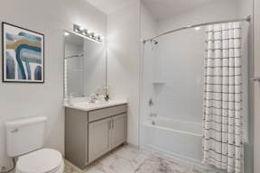 A bathroom with a toilet, sink, and shower.
