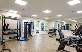 A gym with a variety of equipment including treadmills, weights, and exercise machines.