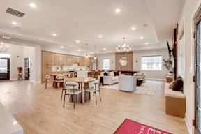 A spacious living room with a dining table and chairs.