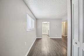 A room with a white door and a window with blinds.