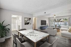 A modern dining room with a large table and chairs.