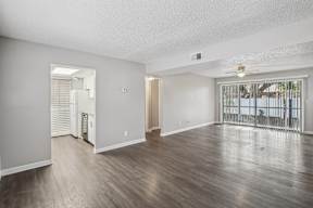 A spacious room with wooden floors and white walls.