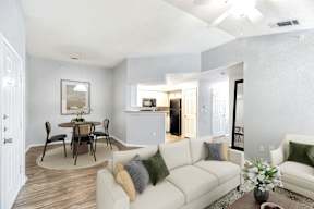 A living room with a white couch and a dining table.