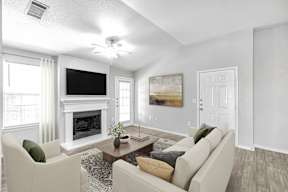 A living room with a fireplace and a television.