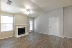 an empty living room with a fireplace and a white door
