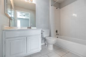 a bathroom with a toilet and a tub and a sink