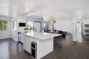 A modern kitchen with a white island and wooden floors.