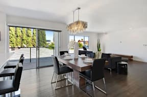 A modern dining room with a view of trees outside the window.