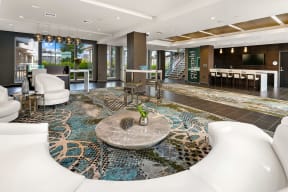 a living room with white couches and chairs and a rug
