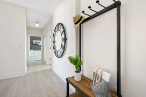 a hallway with a large clock on the wall and a wooden table