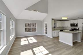 a living room with a kitchen and a large window