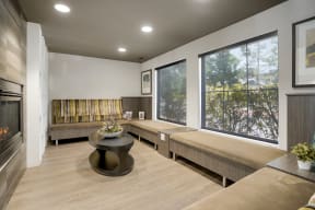 a living room with couches and a fireplace and large windows