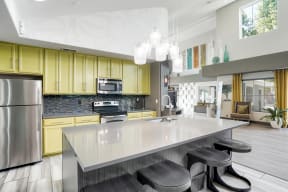 a kitchen with a large island and yellow cabinets