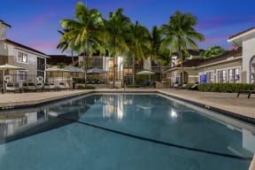 a large swimming pool with palm trees in the background