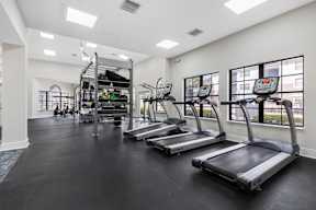 A gym with treadmills, elliptical machines, and a climbing wall.