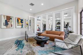 A living room with a brown couch, a coffee table, and a rug.