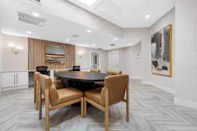 A conference room with a table surrounded by chairs.