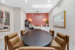 A conference room with a table surrounded by chairs.